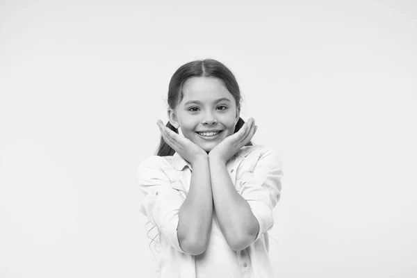 Bebé adorável a sorrir. Cheio de emoção. Menina feliz rosto sorridente toca suas bochechas fundo amarelo. Aluno animado com algo. Criança bonito criança se sente animado. Tão giro. Felicidade infantil — Fotografia de Stock