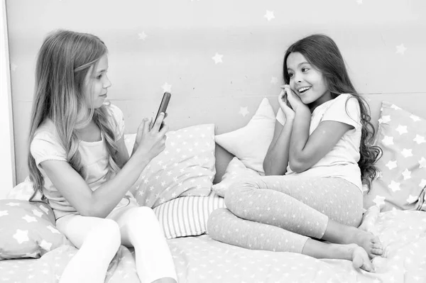 Девушки-друзья фотографируют для социальных сетей. Онлайн канал видеоблога. Сестры в пижаме расслабляют спальню и делают смешные фото для аккаунта в социальной сети. Отдых и веселье. Концепция социальных сетей — стоковое фото