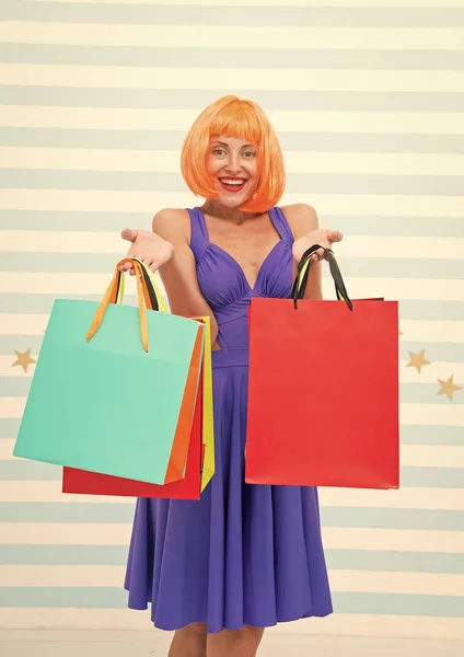 crazy girl shopping. happy woman with orange hair hold purchase. girl with shop bags after big sale on cyber monday. benefit concept. crazy about shopping. shopaholic woman