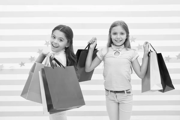 子供は満足ショッピングの縞模様の背景です。ショッピング モールの服と取りつかれています。コンセプトを割引します。子供のかわいい女の子は、買い物袋を保持します。ショッピング割引シーズン。一緒に素晴らしい時間を過ごす — ストック写真