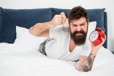 stresli hissediyorum. Çok fazla gürültü var. kızgın sakallı adam ezmek çalar saat. yatak odasında acımasız agresif adam. yatakta sakallı olgun erkek. uykuda ve uyanık. enerji ve yorgunluk. zaman yönetimi