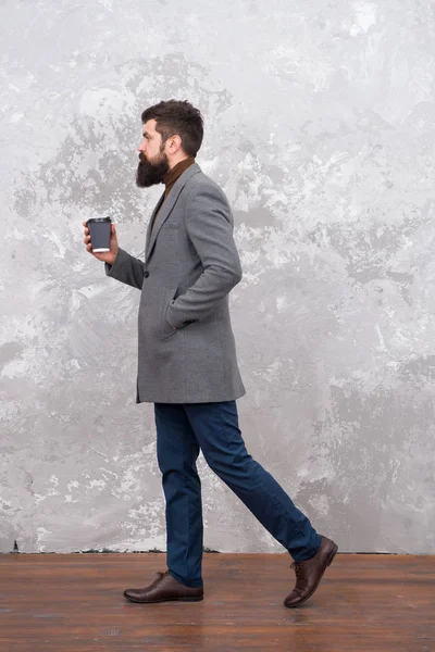 Brutaler bärtiger Hipster in Jeans. Trendiger Mann mit Bart. modernes Leben. Modell für Männermode. Geschäftsleute trinken Kaffee zum Mitnehmen. Casual Style. Neubelebung seiner Energie, um mehr zu arbeiten — Stockfoto