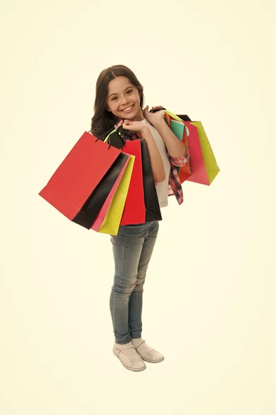 Discounts and promo codes. Girl carries shopping bags isolated on white background. Girl fond of shopping. Child cute shopaholic with bunch shopping bags black friday total sale. Exciting shopping