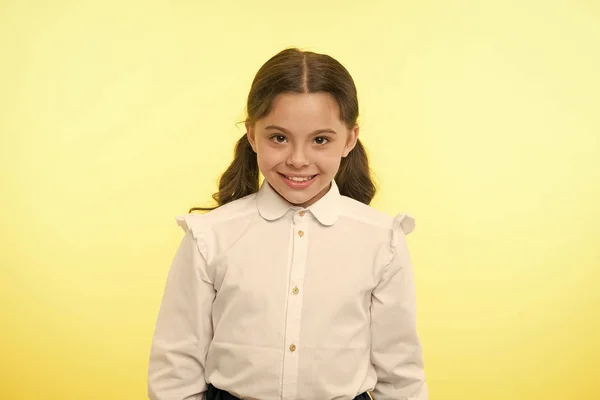 Τόσο χαριτωμένο. Κορίτσι σχολείο στολή χαμογελώντας χαρούμενο πρόσωπο κίτρινο φόντο. Παιδί έτοιμο πίσω στο σχολείο τέλος συνεχίσει εκπαίδευσης. Επίσημη στολή μαθήτρια φαίνεται χαριτωμένος. Ευτυχισμένος πίσω στο σχολείο και μελετώντας το κορίτσι — Φωτογραφία Αρχείου