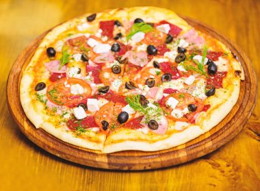 Pizza dereotu ile servis. Pizza domates Siyah Zeytin ve jambon. Gıda kavramı götürün. Pizza restoran. İtalyan pizza kavramı. Ahşap tahta plaka üzerinde lezzetli sıcak pizza. Gıda dağıtım hizmeti