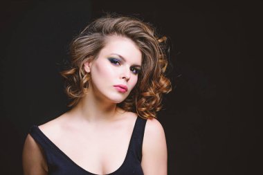 Zarif kıyafeti için makyaj fikir. Zarif çekici kadın dumanlı gözler makyaj ve pembe ruj. Profesyonel makyaj. Güzellik Salonu konsept. Kıvırcık saç ve makyaj siyah arka plan üzerine kadın ile