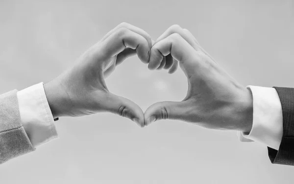 Kéz össze a szív alakú kék ég háttér. Kézzel szív gesztus formák alakú ujját. Férfi kezét a szív alakú megfelelő kézmozdulat-szimbólum a szeretet és a romantika. Szerelmi szimbólum fogalom — Stock Fotó