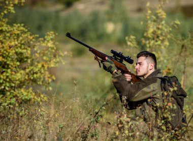 Avcılık ve yakalama mevsimleri. Sakallı ciddi avcı boş zamanlarını avlayarak geçiriyor. Hunter tüfeği tutuyor. Adam kamuflaj giysileri doğa arka plan giymek. Avlanma izni. Avcılık acımasız erkeksi hobi