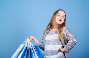 pazarlık satış. Çocuk modası. paket ile mağaza asistanı. Satışlar ve indirimler. Alışveriş poşetleri olan küçük bir kız. Mutlu çocuk. Yetenekleri olan küçük bir kız. özel teklif. Tatil satın alma tasarrufu. Bu bir pazarlık.