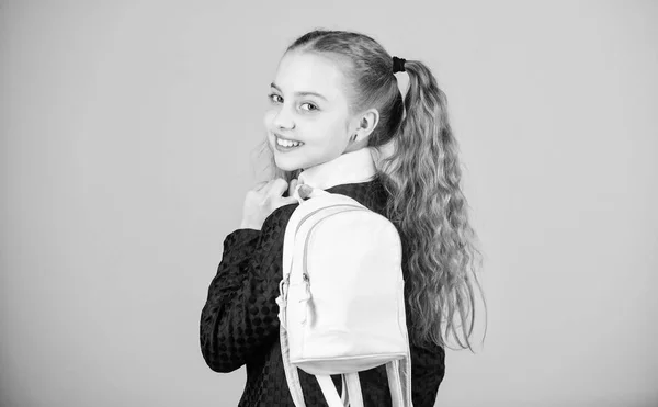 Carrying things in backpack. Schoolgirl ponytails hairstyle with small backpack. Learn how fit backpack correctly. Girl little fashionable cutie carry backpack. Popular useful fashion accessory — Stock Photo, Image