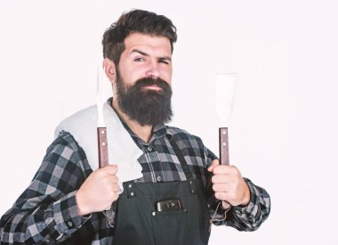 En iyi Barbekü tencere. Barbekü araçları elinde tutan sakallı adam. Spatula ve barbekü çatalı kullanarak yemek ızgara. Mutlu hipster Barbekü gıda hazırlama için paslanmaz çelik araçları holding