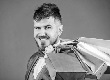 Adam sakallı zarif işadamı gri arka plan üzerinde alışveriş torbaları taşımak. Alışveriş daha neşeli hale getirin. Seçkin butik. Karlı fırsatlar siyah Cuma alışveriş keyfini çıkarın. İndirimli alışveriş keyfini satın alma