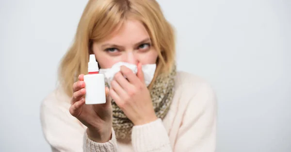 Finding relief just a spray away. Sick woman spraying medication into nose. Ill girl with runny nose using nasal spray. Cute woman nursing nasal cold or allergy. Treating cold or allergic rhinitis — Stock Photo, Image
