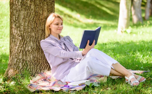 女商人找分钟读书提高了她的知识。女性自我提高。女孩靠在树上，而放松在公园坐草。自我改进书。自我提高与教育理念 — 图库照片