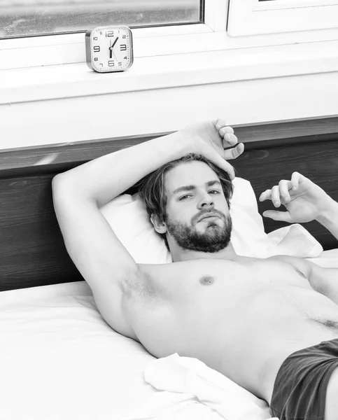 Un joven despertando en la cama y estirando los brazos. Un hombre guapo bostezando y estirando los brazos. Hombre bostezando mientras despierta . — Foto de Stock