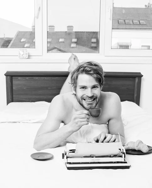 Author having breakfast in bed drink coffee. Morning inspiration. Coffee inspiring him to write. Writer romantic author used old fashioned typewriter. Man writer lay bed bedclothes working book