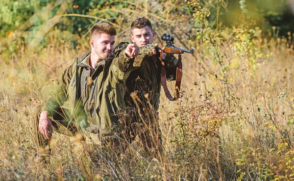 Hunting with friends hobby leisure. Hobby for real men concept. Hunters with rifles in nature environment. Hunter friend enjoy leisure in field. Hunters gamekeepers looking for animal or bird