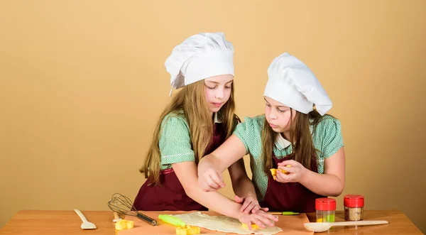 Lubią gotować. Urocze dziewczynki cieszyć się gotowania razem. Małe dzieci biorą lekcje gotowania. Słodkie kucharze w gotowania fartuchy kształtowania figury z ciasta z form — Zdjęcie stockowe