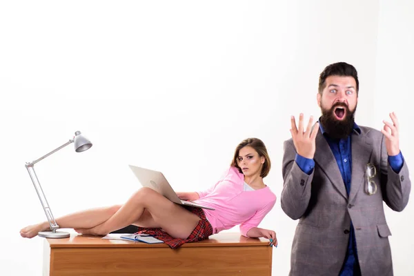 Bad news. Angry businessman shouting at secretary lying on desktop. Bearded man with open mouth on angry face. Hipster being angry about business problems. Feeling angry