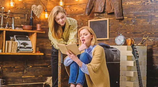 Girls excited about new work by favorite writer, literature discussion club, poetry night. Bookworms, mother and daughter, reading fascinating book in living room of wooden countryside house — Stock Photo, Image