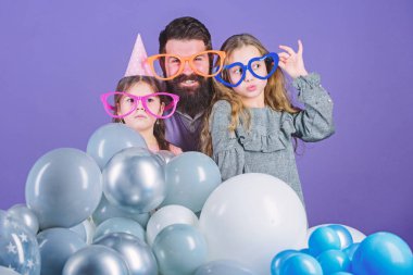 Kızların hayata aktif olarak ilgi duydukları babaya ihtiyacı var. Doğum günü partisi. İki kızı olan baba eğleniyor. Baba kavramı. Dost aile eğlenceli parti aksesuarları giymek. Şimdiye kadarki en iyi babam. Babalar günü