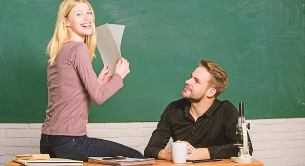 Satisfied with her marks. Couple studying in classroom. Pretty teacher and handsome schoolmaster grading papers. University or college students. Man and woman back to school. High school education — Stock Photo, Image