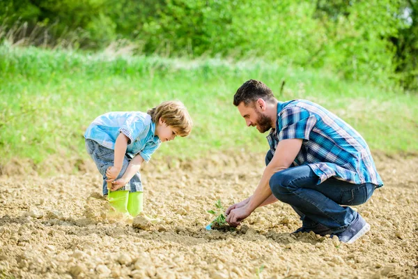 mutlu dünya günü. Aile ağacı. zengin doğal toprak. Eko çiftlik. küçük çocuk çocuk tarım baba yardım. yeni bir hayat. Ekolojik mühendislik. baba ve oğul toprağa çiçek ekiyor. toprak gün