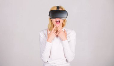 Sanal gerçeklik giyen kadın gri arka planda gözlükler. Genç kadın Vr deneyimi sırasında hava dokunmadan hayran. Mutlu kadın artar dünya keşfetmek dijital arabirimi ile etkileşim.