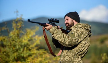 Avcılık ve yakalama mevsimleri. Avcılık erkeksi hobi. Adam acımasız gamekeeper doğa arka plan. Hunter tüfeği tutuyor. Sakallı avcı boş zamanlarını avlayarak geçirir. Odak ve deneyimli avcı konsantrasyonu