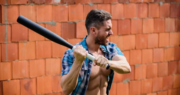 Homme visage non rasé torse musculaire tenir batte de baseball noire. Un tempérament fort. Faites confiance à sa force. Bully guy carry cudgel mur de briques fond. Puissance et force. Concept d'attaque. Ressens ma force — Photo