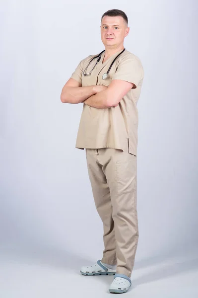 Clínica privada. Carrera de doctor. Hombre doctor estetoscopio médico uniforme. Medicina y salud. Tratamiento y prevención. Chico experimentado médico ropa beige sobre fondo blanco. Comprobar la salud — Foto de Stock