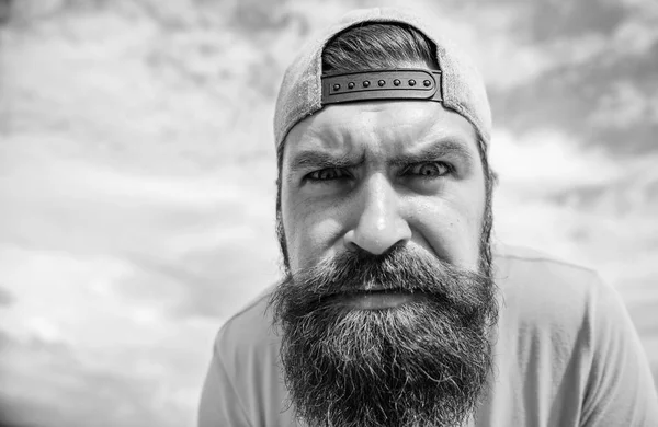 Staren rechtstreeks voor hem. Brutale man met lange baard en serieuze blik. Bebaarde man in mode hipster GLB buiten. Hipster in straat mode dragen op bewolkte hemel. Coole hipster — Stockfoto