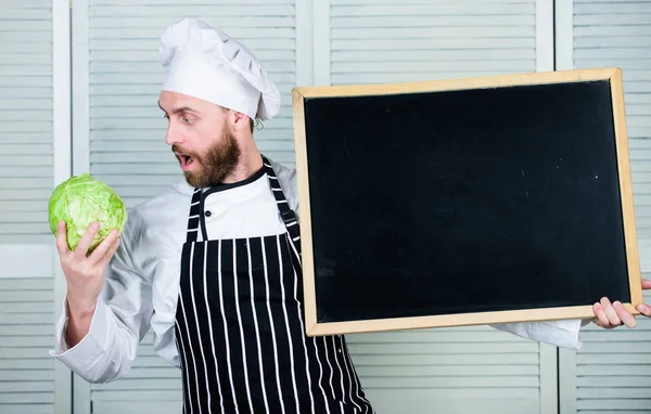 Concepto de receta. Cocinar deliciosa comida paso a paso. Menú para hoy. Lista de ingredientes para cocinar plato. Mira los consejos de cocina. Consejos para cocinar como profesional. Hombre chef sombrero delantal mantenga el espacio de copia pizarra — Foto de Stock