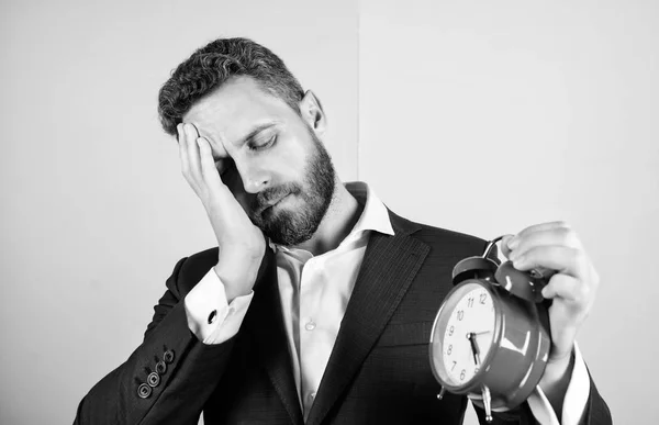 ストレスの概念。中年の男性のひげは、仕事のために疲れています。ビジネスマンは時間の不足です。時間管理のスキル。締め切りまでの残り時間。作業する時間。眠そうなビジネスマン ホールド時計にひげを生やした男 — ストック写真
