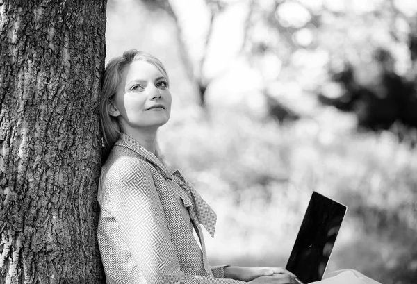 Minute for relax. Girl work with laptop in park sit on grass. Education technology and internet concept. Natural environment office. Work outdoors benefits. Woman with laptop work outdoors lean tree