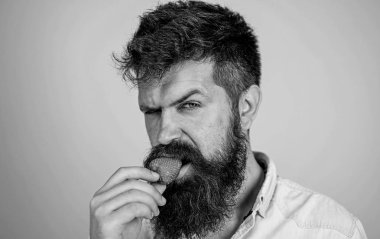 Uzun sakallı adam yakışıklı katı yüz seksi hipster çilek deneyin. Gastronomik zevk. Arzu kavramı. Oral muamele. Hipster sulu olgun kırmızı çilek tadını çıkarın. Adam tatlı çilek yeme