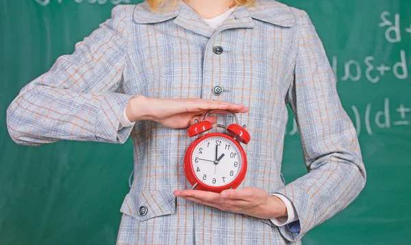 Schuldisziplinarkonzept. Zeitplan und Regime. Wecker in Frauenhänden schließen. Lehrerattribute. Wecker in den Händen des Lehrers oder Pädagogen Klassenzimmer Tafelhintergrund — Stockfoto