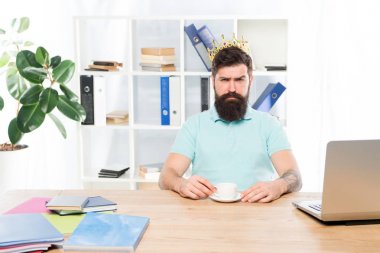 Altın taçlı işadamı kralı. iş kralı. Ciddi adam kahve içmek. Patron işyeri. İş ofisindeki sakallı adam. egoist. kendini büyük patron hayal. ödül ve başarı. iş kralı