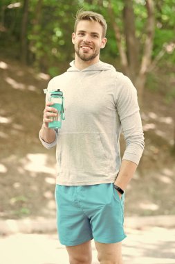 Adam atlet şişe bakım nemlendirici vücut egzersiz yaptıktan sonra tutun. Büyük iş sonra ferahlatıcı vitamin içeceği. Adam atletik görünüm su şişesi tutar. Sporcu içmek su Park eğitimden sonra