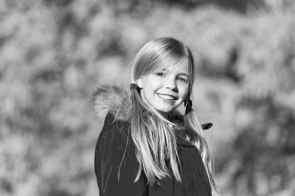 Moda de otoño. Chica sonriente cara lindo peinado abrigo de otoño de moda con capucha y piel. Niña usar abrigo para la temporada de otoño. Niño alegre caminando usando abrigo cálido brillante o chaqueta caída día soleado — Foto de Stock