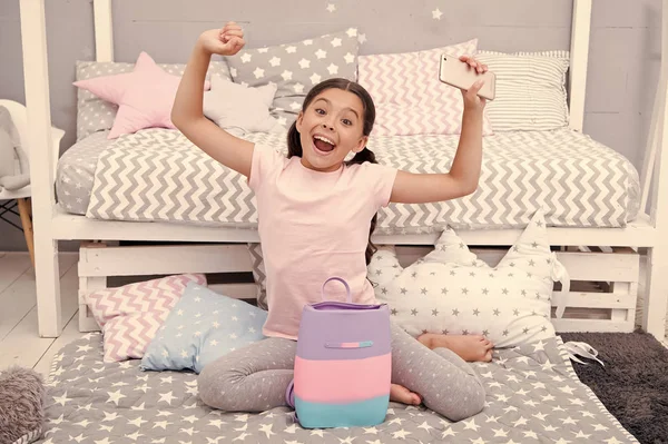 Um conceito de criança feliz. Criança menina feliz com saco de presente. Criança feliz tem smartphone para presente. Celebração de aniversário feliz para criança — Fotografia de Stock