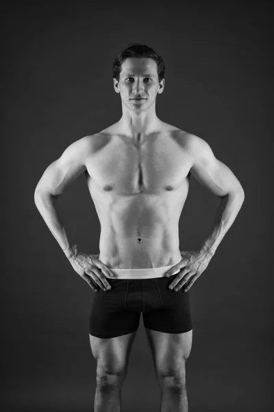 Muskulöser Mann mit kräftigem Körper. Sportler beim Aufwärmen vor dem Training. Sport und Fitness. Sportler in roten Shorts. Vertrauen in sein Fitnesssystem. Mann beim Training im Fitnessstudio. passen Sie Ihren Körper an und verlieren Sie Gewicht — Stockfoto