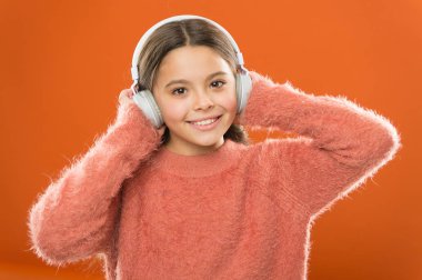 Sevdiğin şarkılara benzer yeni bir müzik bulmanın en kolay yolu. Sevimli küçük kız kulaklık takıyor, müzik dinliyor. Çocuk müzik dinle turuncu arka plan. Önerilen müzik başlangıçtaki ilgiye dayanır