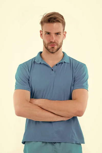 Man with trendy hairstyle and small bristle isolated on white background. Sportsman in blue outfit on training, health and fitness concept. Athlete with sexy muscular body folding arms at his chest — Stock Photo, Image