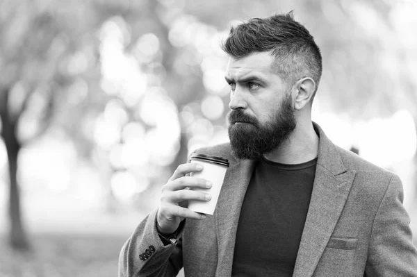 A szakállas hipszter jobban szereti a kávét elvinni. Az üzletember kávét iszik a szabadban. Energiát töltök. Nyugtató kávészünet. Hipster tartsa papír csésze kávé és élvezze a természet környezetében. Idd meg útközben. — Stock Fotó