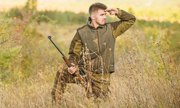 Hunting permit. Bearded hunter spend leisure hunting. Hunter hold rifle. Focus and concentration of experienced hunter. Hunting and trapping seasons. Man brutal gamekeeper nature background