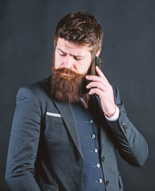 Yeni bir iş günü. Sakallı adam ile smartphone. Erkek resmi moda. Bıyıklı acımasız beyaz hippi. Takım elbiseli bir iş adamı. iş iletişimi. Olgun hipster sakallı telefonla konuşabilir