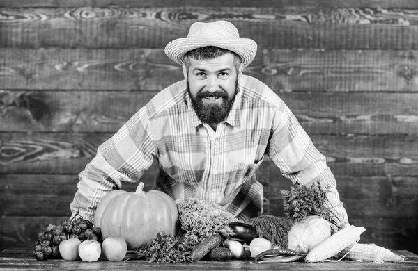 Man bearded farmer with vegetables rustic style background. Buy vegetables local farm. Locally grown crops concept. Local market. Homegrown vegetables. Farm market harvest festival. Sell vegetables