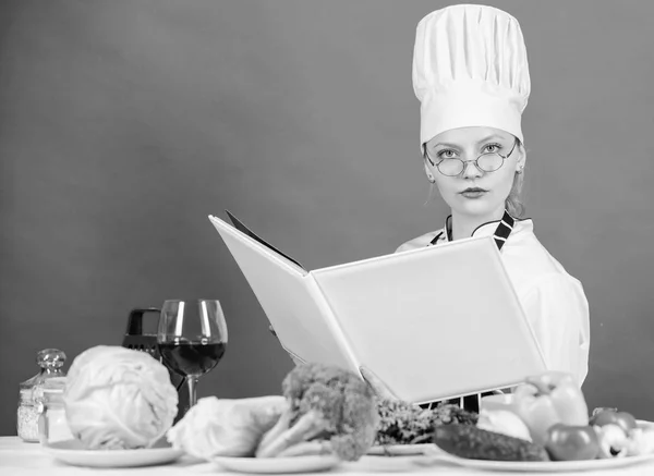 Culinary expert. Woman chef cooking healthy food. Girl read book top best culinary recipes. Traditional cuisine. Culinary school concept. Female in hat and apron knows everything about culinary arts