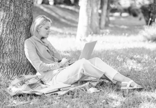 Naturliga miljön office. Arbeta utomhus fördelar. Kvinna med laptop datorarbete utomhus lean på trädstam. Utbildning teknik och internet koncept. Flicka arbete med laptop i park sitta på gräset — Stockfoto